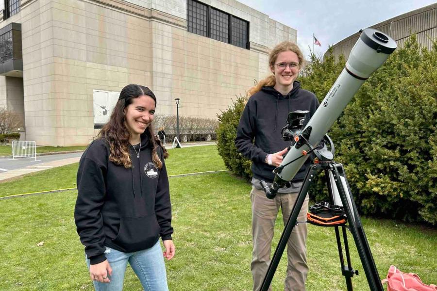 two people standing with telescope