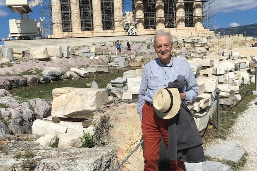 Person standing on a path in front of columned ruins of the Parthenon 