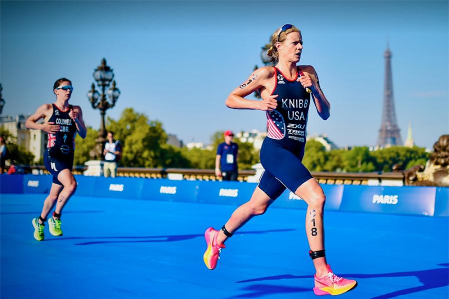 Person in racing gear runs on a blue pathway with the Eiffel Tower in the background