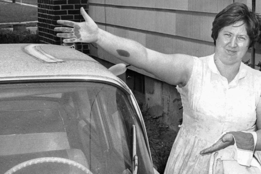 A Baltimore woman wipes soot from the roof of her car in a photo dated July 8, 1967.