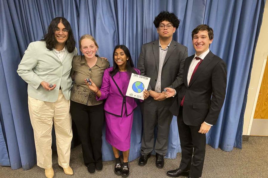 five people holding a plaque