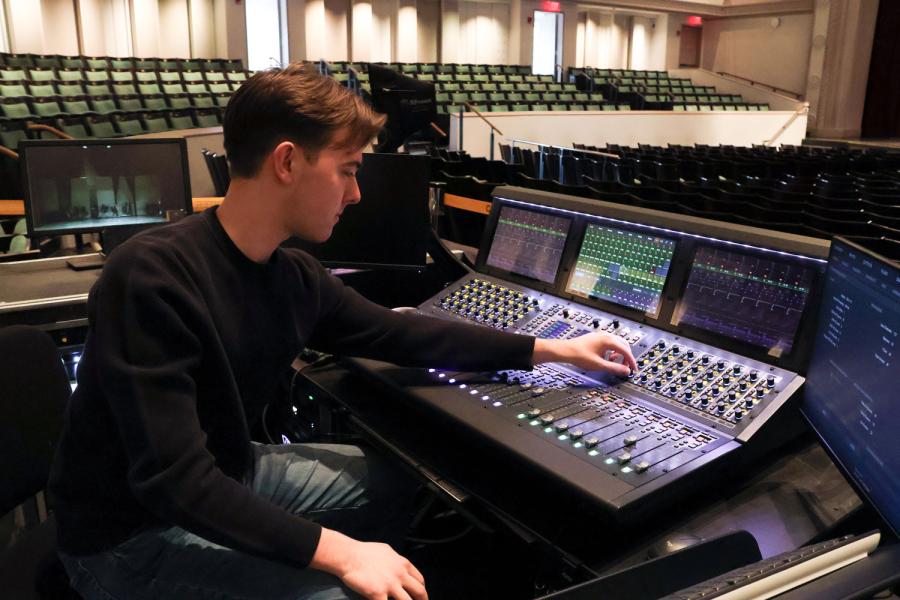 person at a mixing board in a music studio