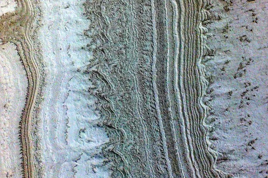 Multi-colored, uneven bands, some straight, some with curved projections, represent ice layers