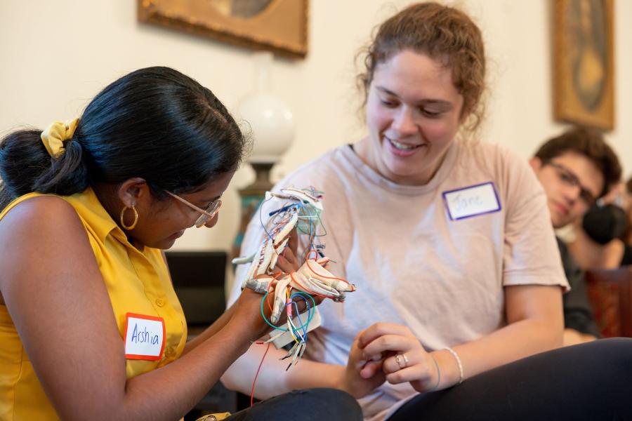 Milstein Program students looking at a device