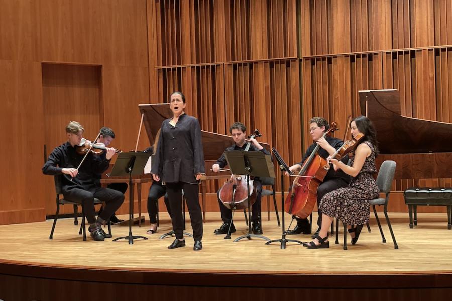 Six musicians--a singer, four string players and a pianist--perform on stage