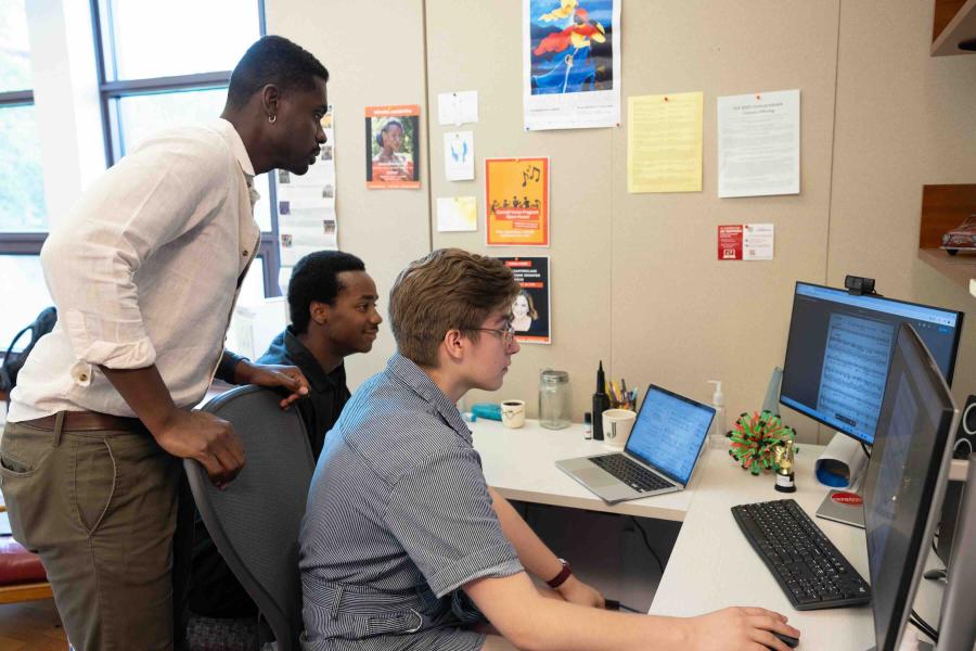 three people working on a computer