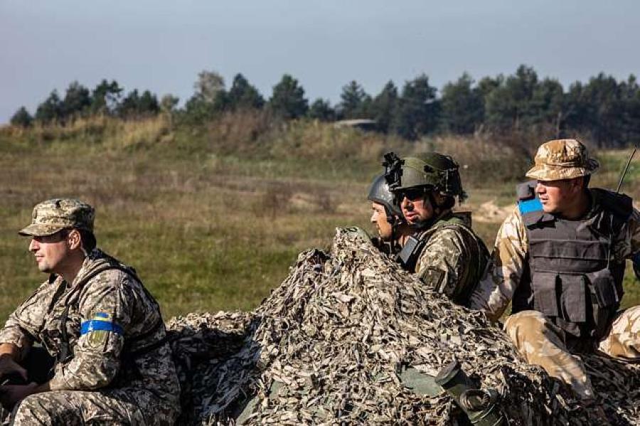 A few solders in camoflauge in a field