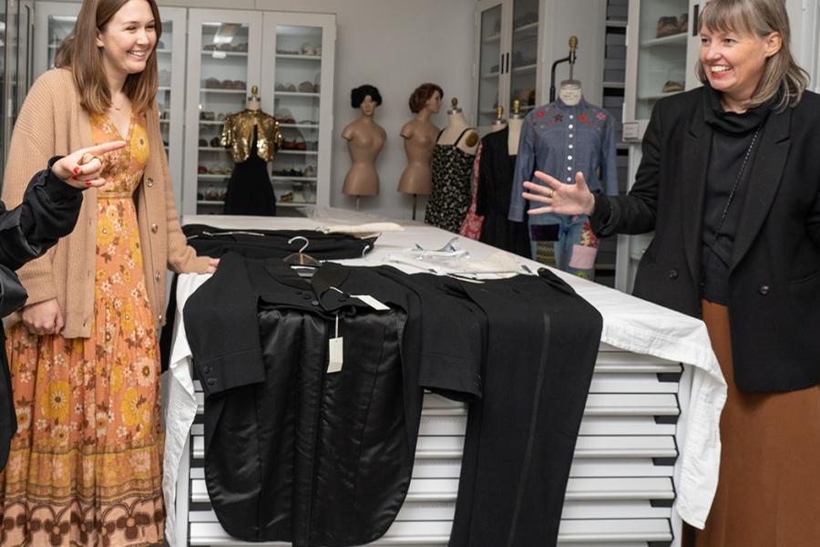Four people with a few garments between them, on a table