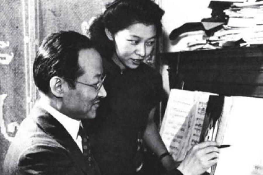 two people looking at sheet music that's sitting on a piano