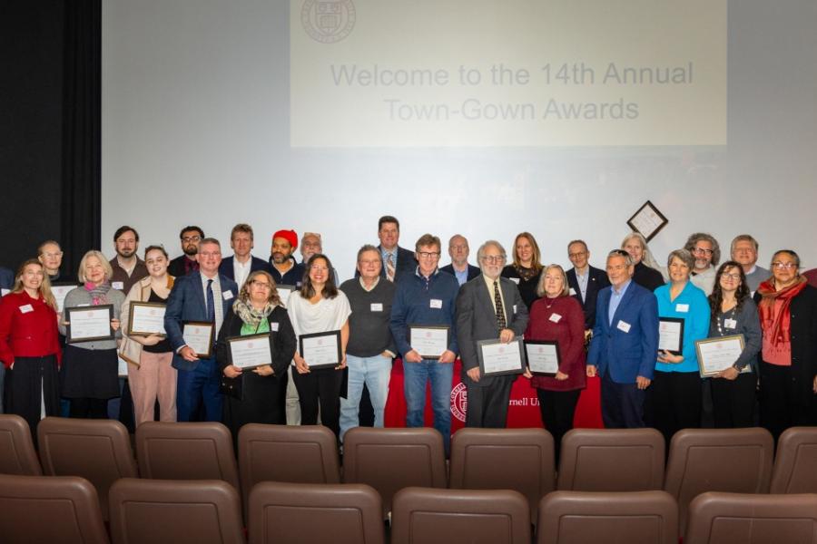 A few dozen people stand in front of a movie screen