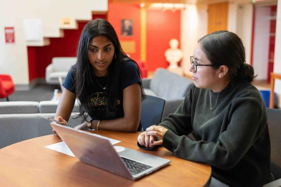 Two people looking over a text on a computer 