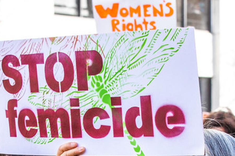 Person holding a sign "Stop femicide"