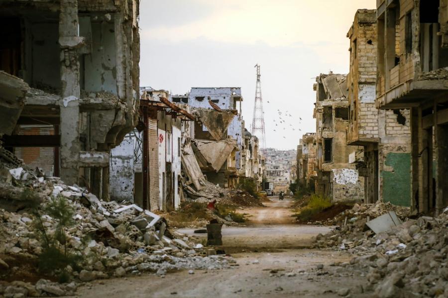 Looking down a desolate street damaged by war