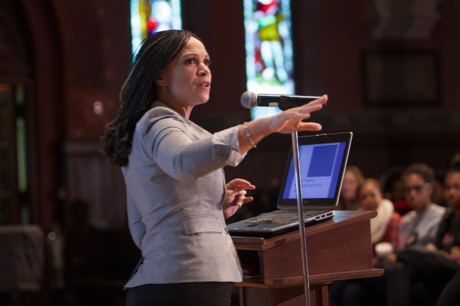 Person speaking at a podium with stained glass windows in the background