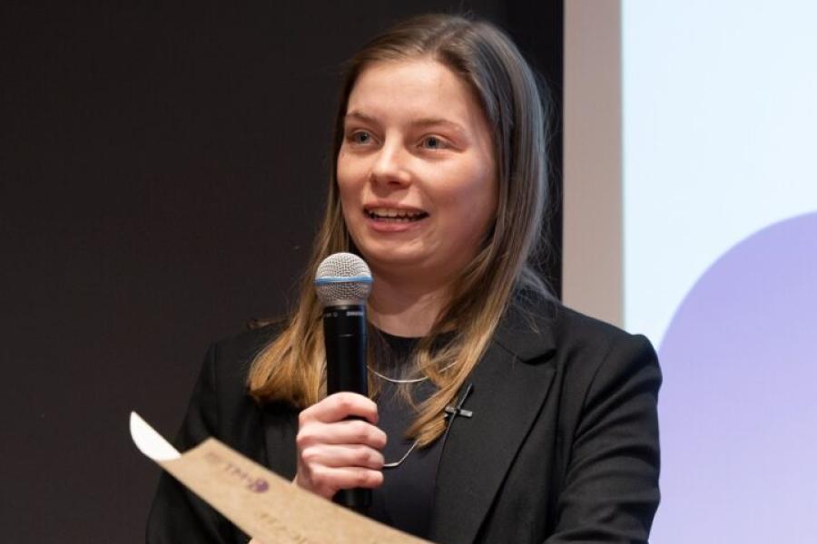 Person holding a microphone and a certificate