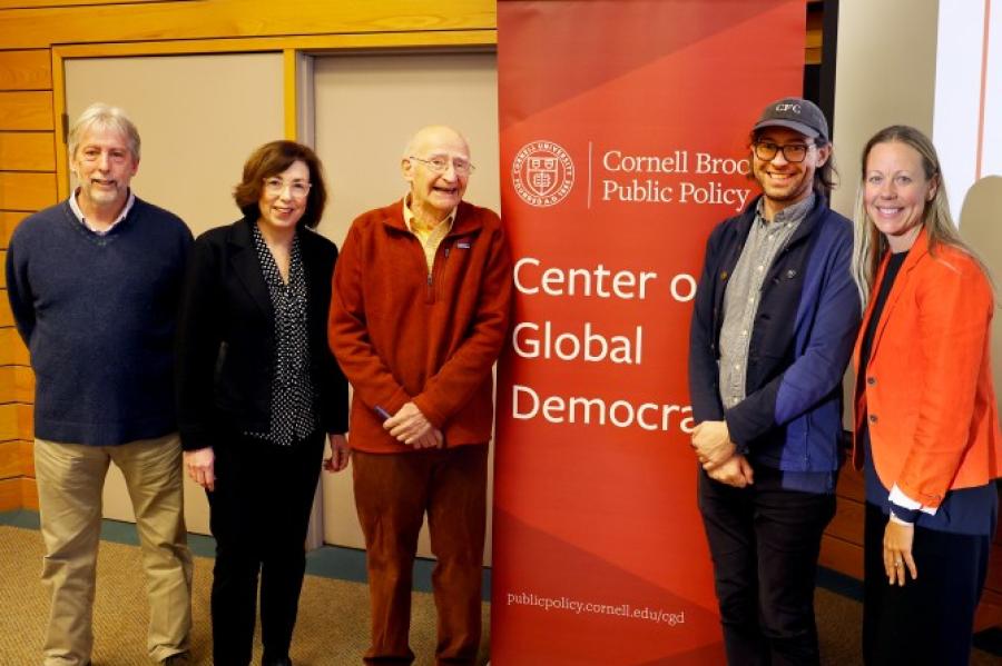 Five people stand near a sign that says "Center on Global Democracy"