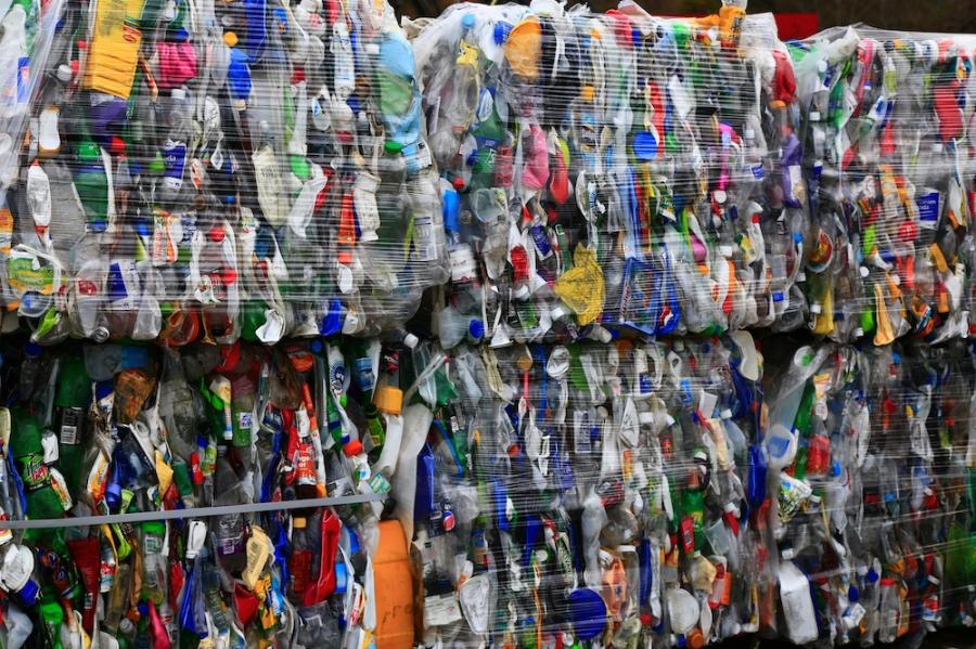 Plastic items in many colors crushed together and wrapped for recycling