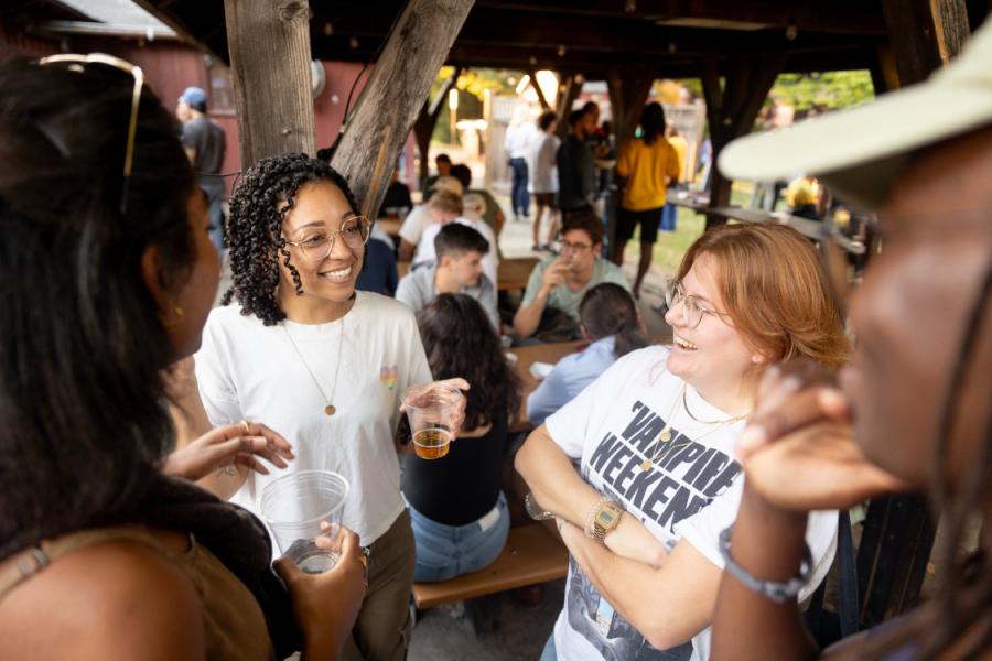 Four people stand in a circle, chatting and smiling