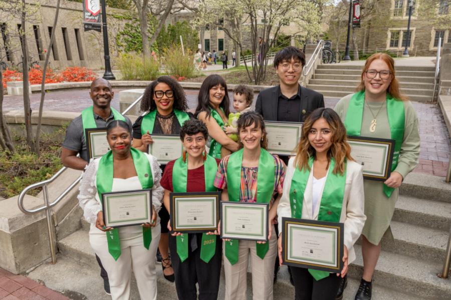 Eight people wearing green academic stoles (plus one baby)