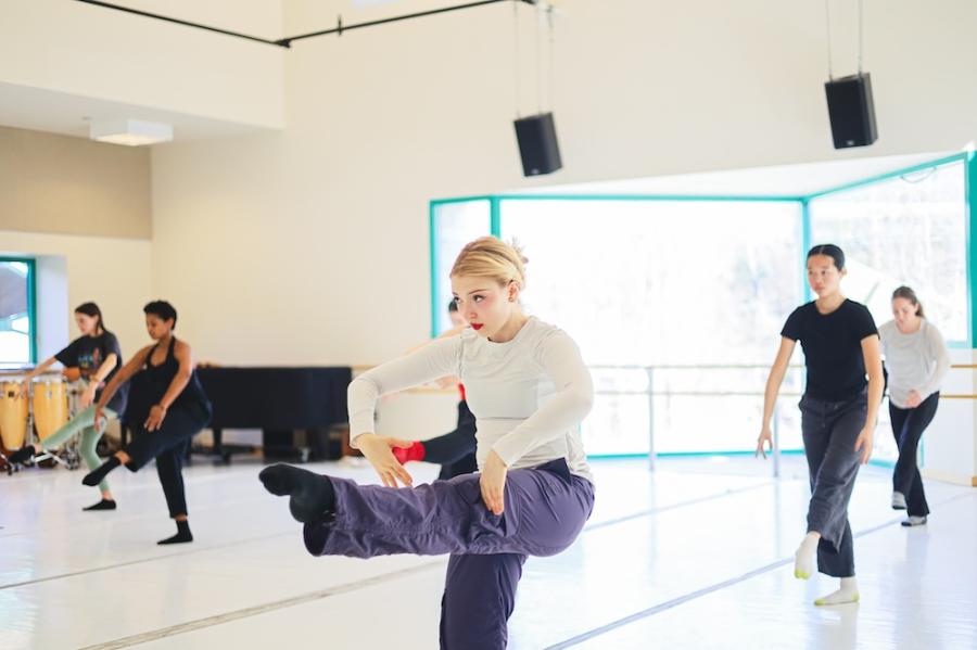 Several people dancing in formation in a sunny studio