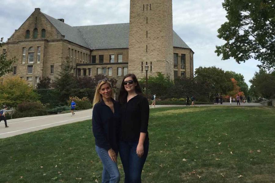 two people standing near McGraw Clock Tower