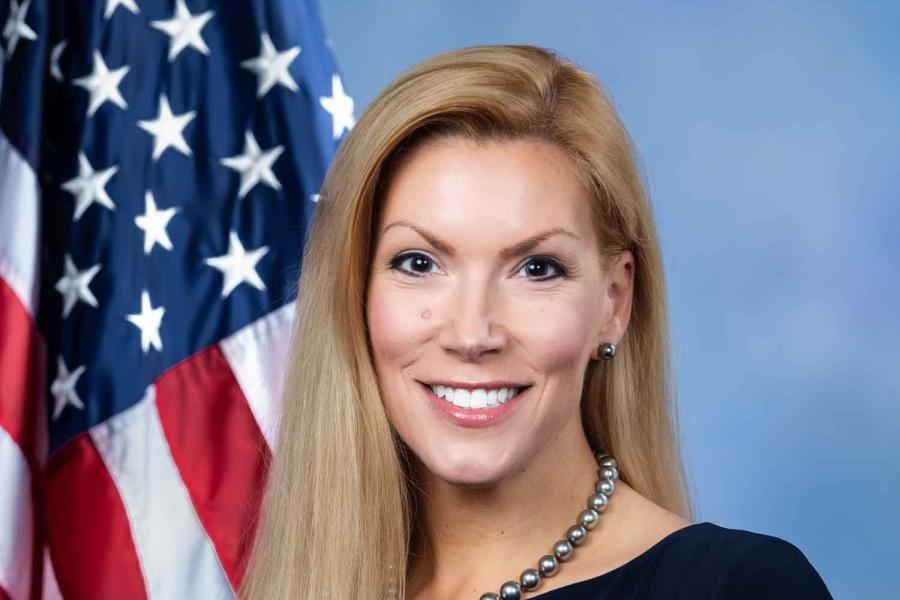 person smiling by American flag