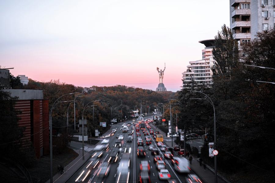 Cars speed down a six-lane road through a city