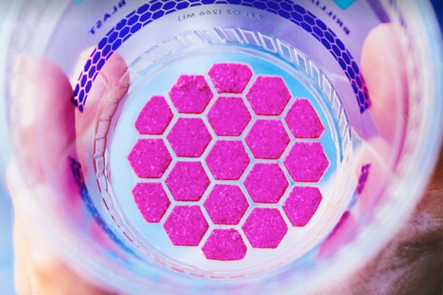 Looking closely at the inside of a plastic cup that has a circle of fuscia hexagons stuck to the bottom 