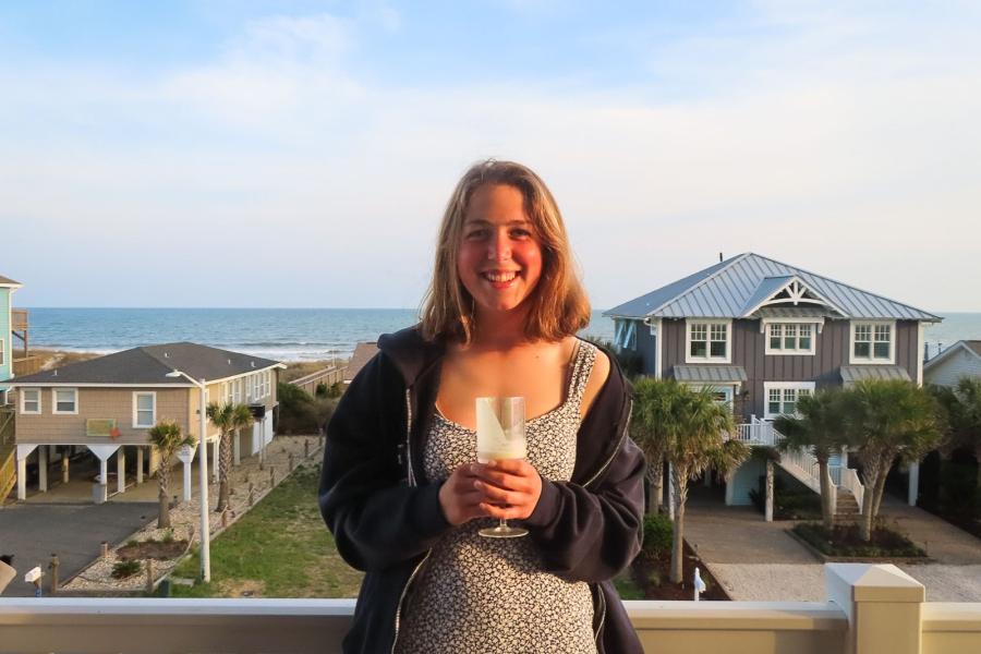 person standing at a balcony overlooking the beach