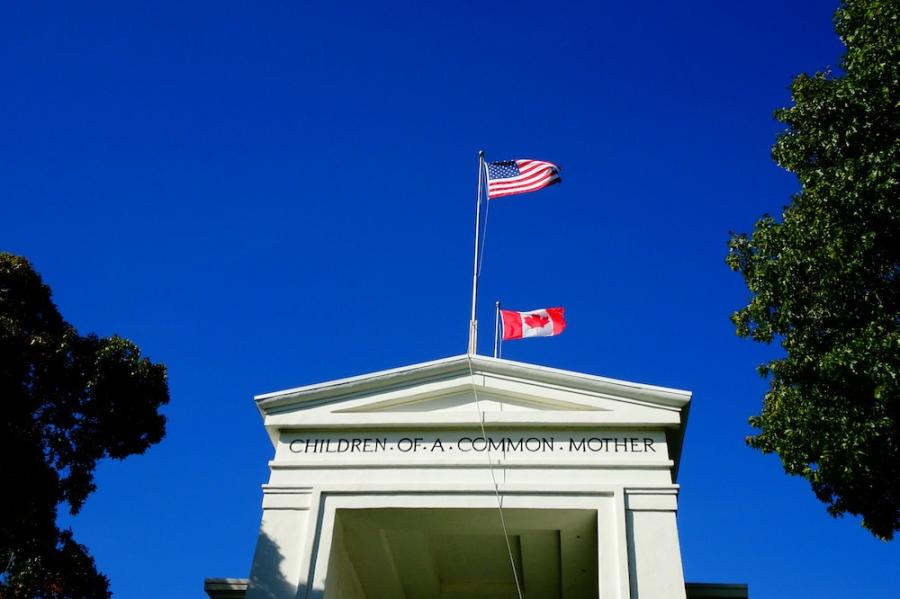 White stone building with two flags flying over it