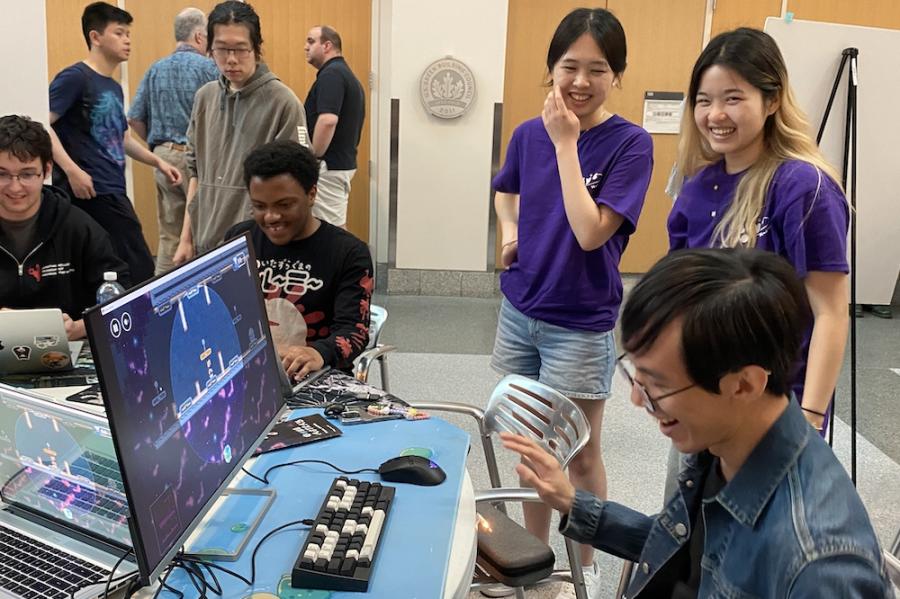 Several people gathered around a table with computer games