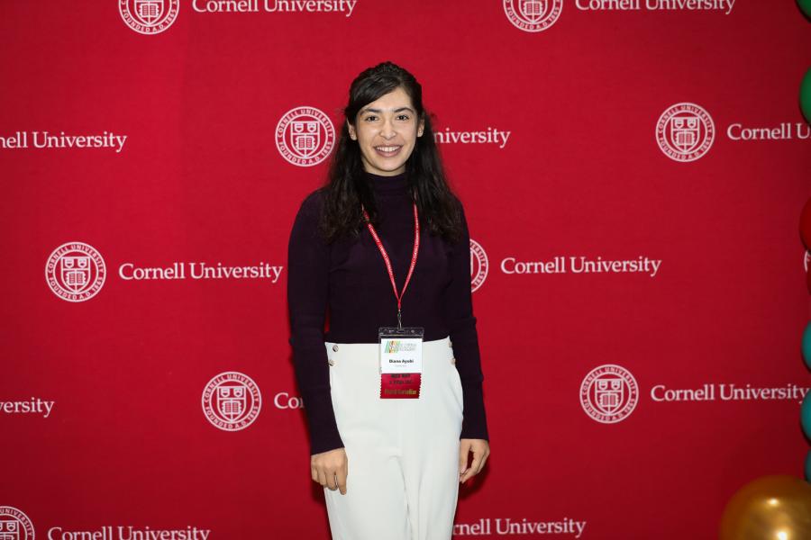 person in front of background with Cornell University written on it