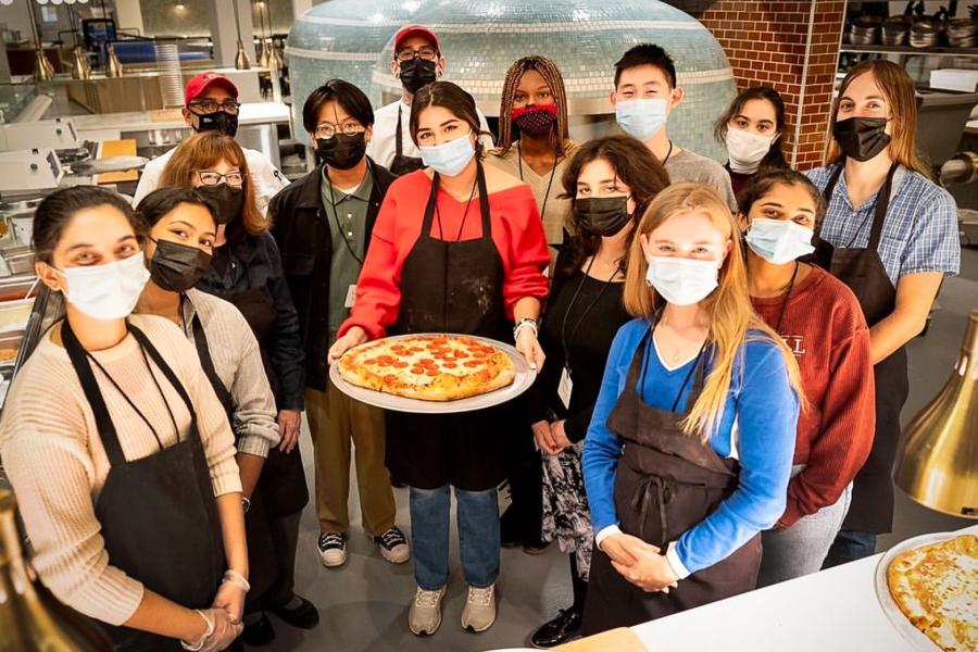 people holding a pizza