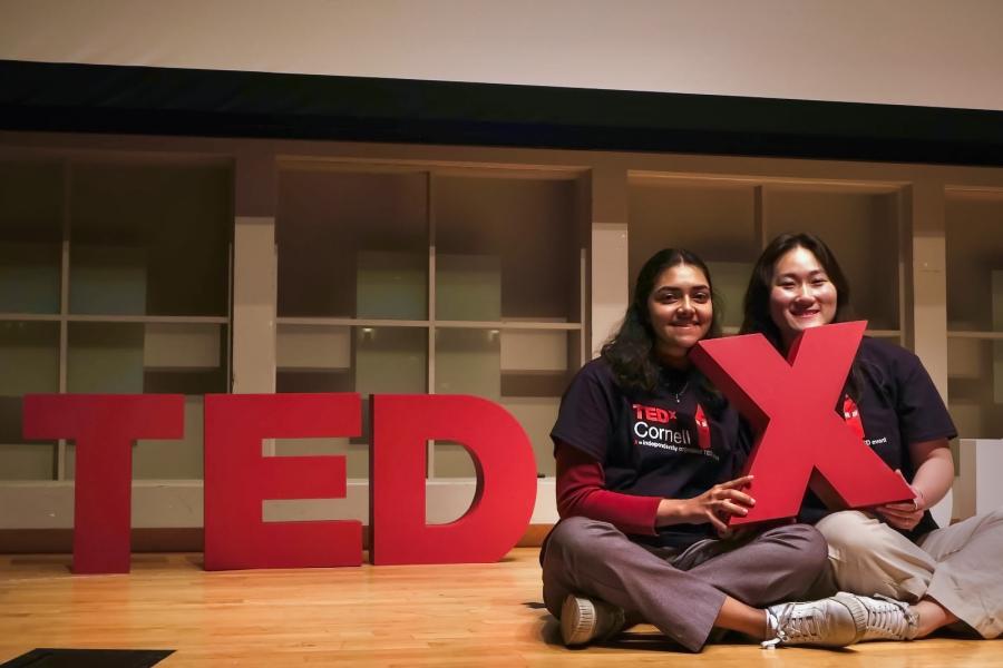 two people on stage with a TedX sign