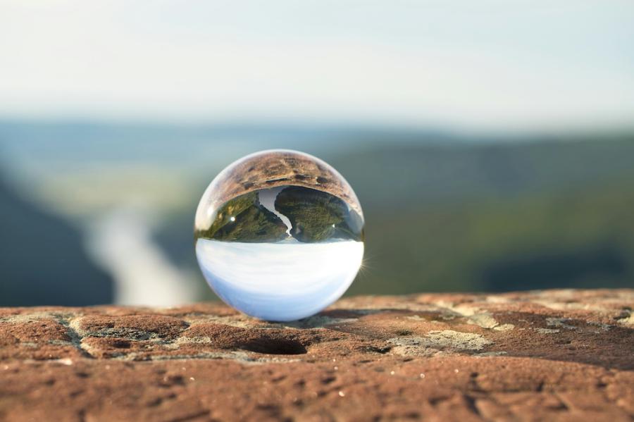 crystal ball reflects a view of a river, upside down