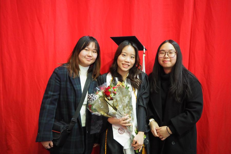 person in graduation gowns with two other people