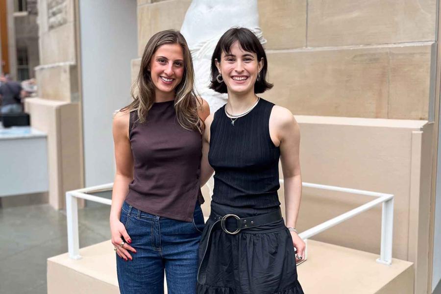 two people standing in front of a statue