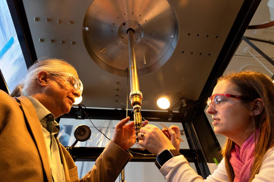 Professor of chemistry working with with a doctoral candidate to inspect a electrostatic force microscope