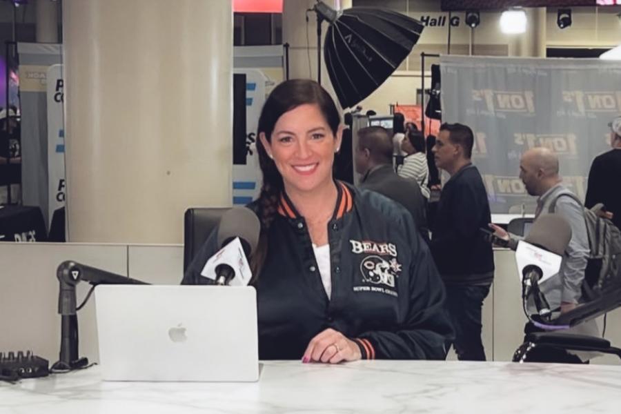 Person wearing a Bears jacket sitting at a computer in a press room