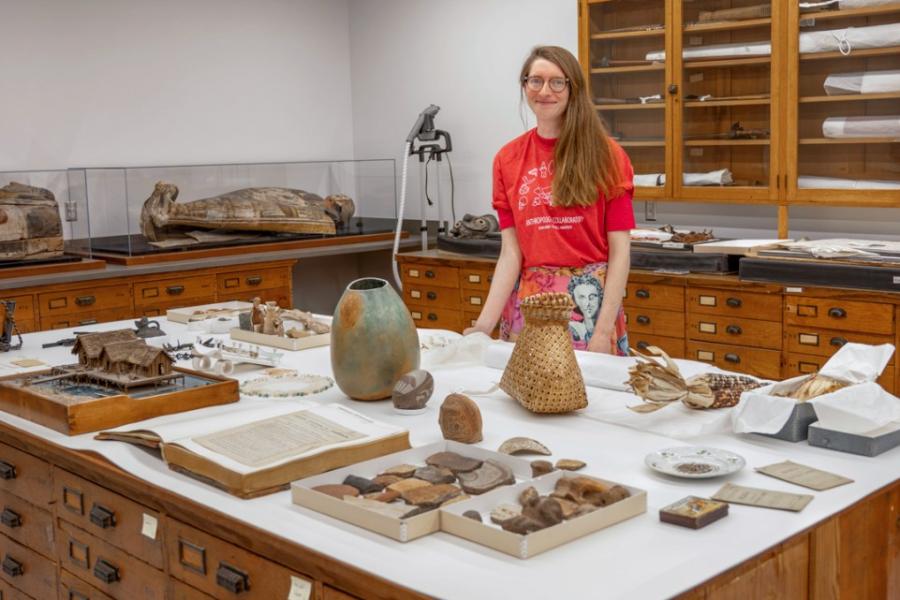 Person standing behind a table covered with artifacts