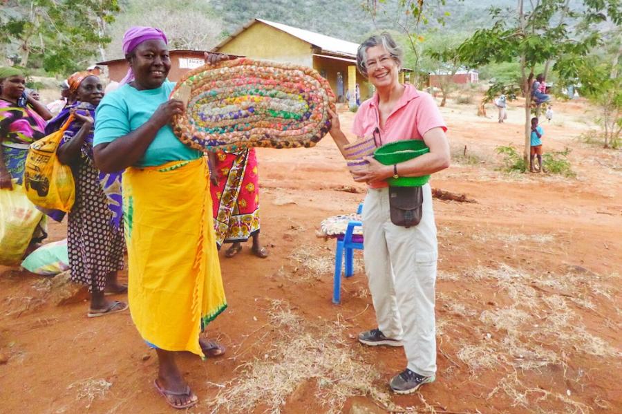 Two people holding a large, colorful basket between them