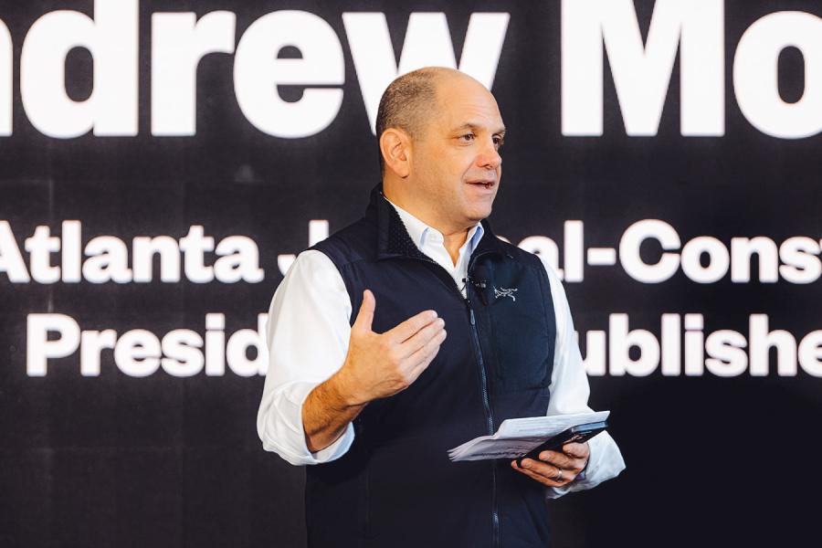 Person wearing a black vest and white shirt, speaking publically