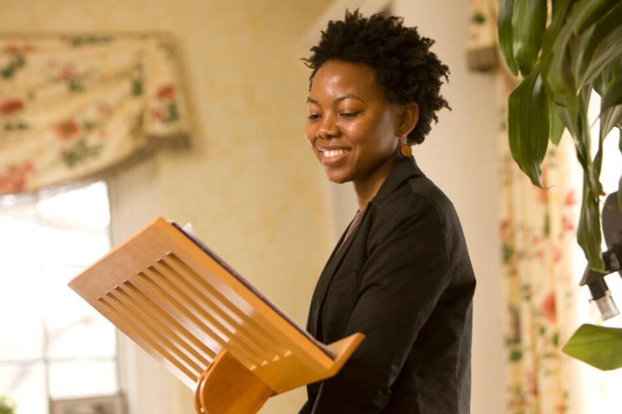 Person standing at a small podium, smiling