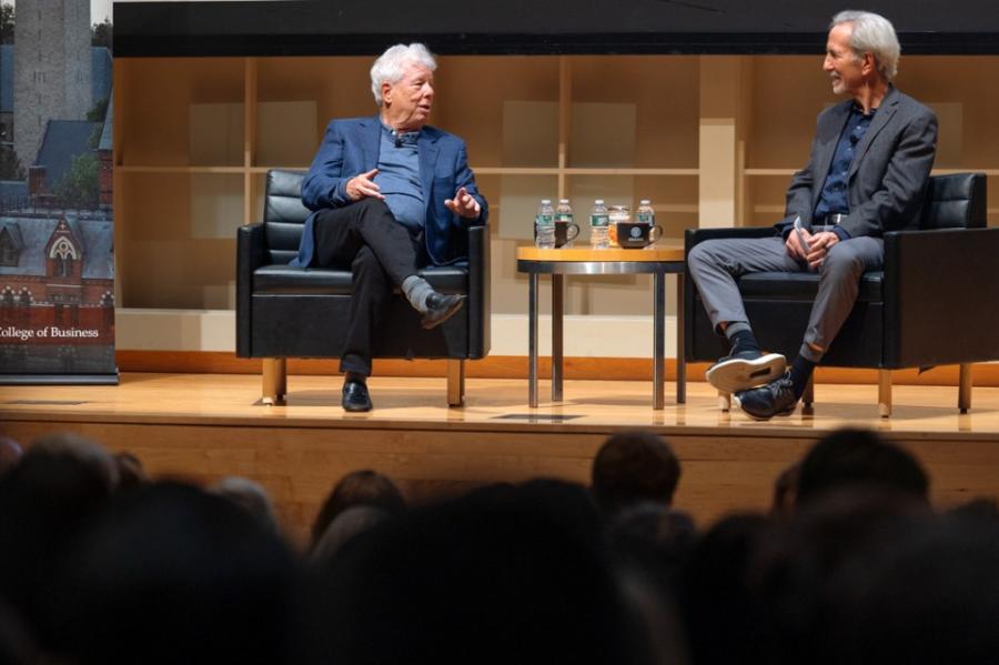 Two people conversing on a stage during an event