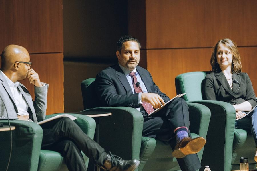 Three people sitting in arm chairs during an on-stage event