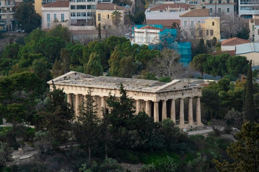 Ancient stone building near modern buildings in Athens, Greece