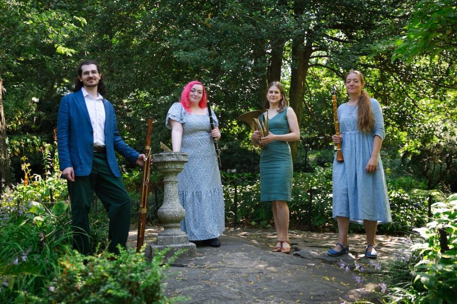 Four people stand in an outdoor setting