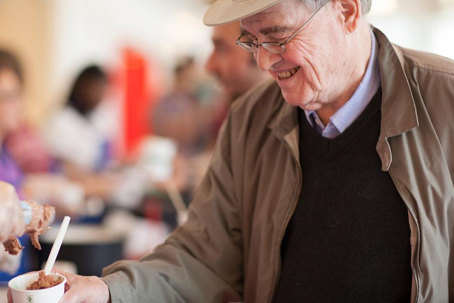 Person smiling down at a cup of ice cream