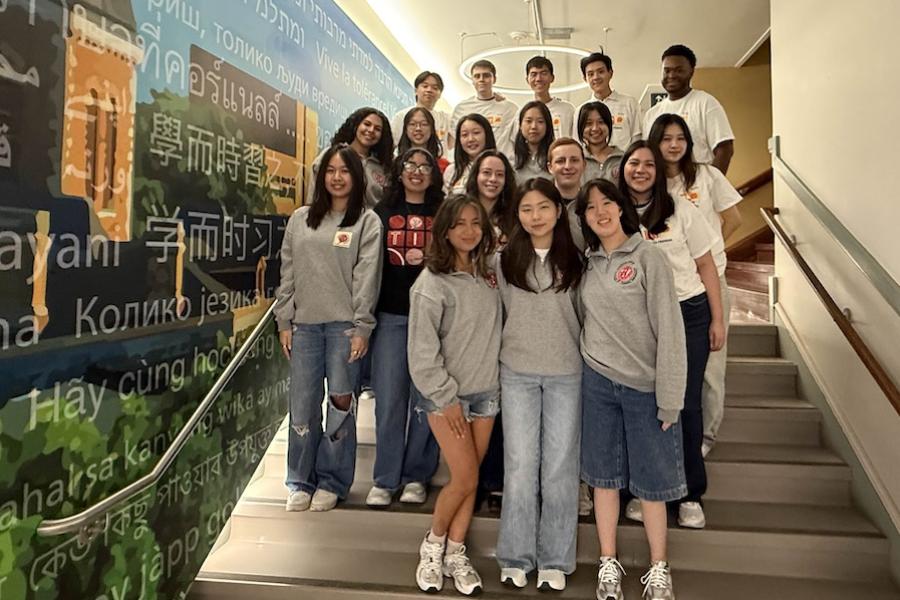 About 20 people pose as a group on a staircase. 
