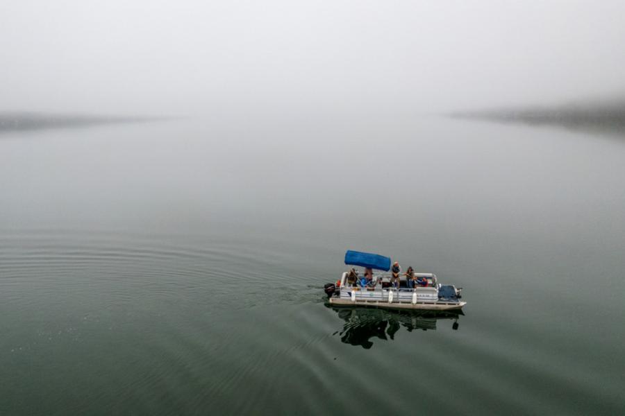 Pontoon boat on still, gray water